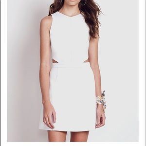 Sleek white mini dress with cutout and gold zipper